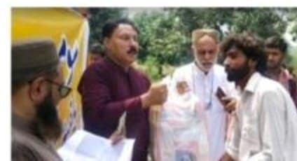 A ration bag handed over while a name is checked against a list