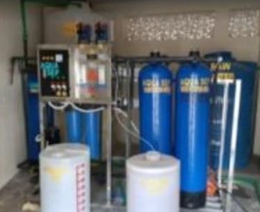 The reverse osmosis unit indoors, blue pressure vessels and white tanks